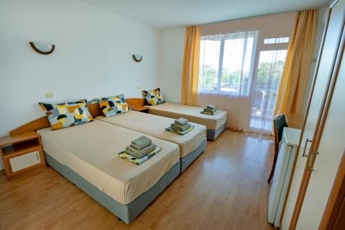 a bedroom with two beds and a large window at Hotel Aia Kavatsi in Sozopol