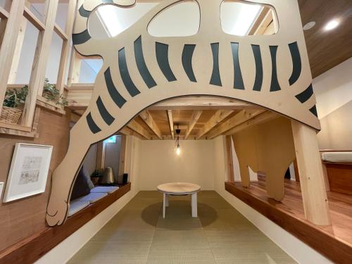 a room with a table and a zebra sign on the wall at Le Cave Troll ル カーブ トロル in Mitaka