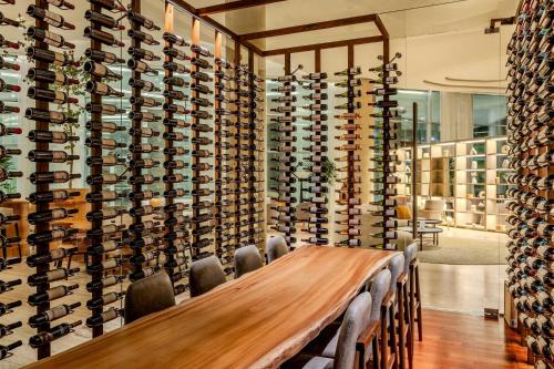 a conference room with a wooden table and a wall of wine bottles at Marriott Corrientes in Corrientes