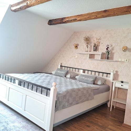 a bedroom with a white bed and a desk at Dachstübchen mit 2 Zimmern in Boizenburg