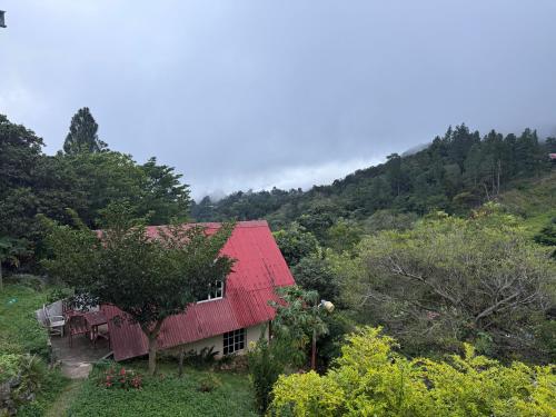 a house with a red roof on a hill at Cabaña vista Volcán Barú in Gualaca