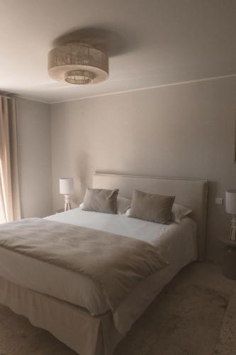 a bedroom with a large white bed with two pillows at Hôtel Pineto in Biguglia