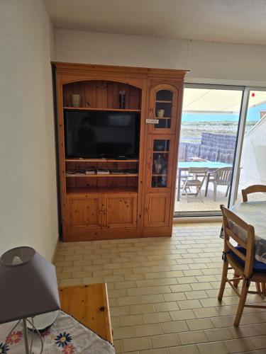 a living room with a television and a table at directe plage à moins de 100m in La Turballe