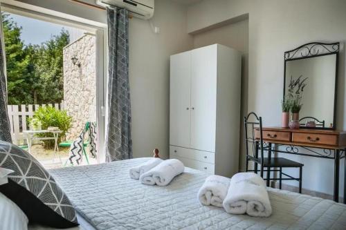 a bedroom with a bed and a desk and a window at Villas LaVista in Skala