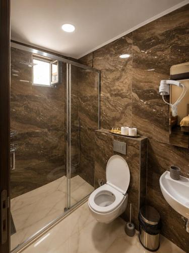 a bathroom with a shower and a toilet and a sink at Grand Clochē in Ulcinj