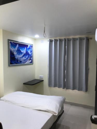 a bedroom with a bed and a window with curtains at Hotel keshri Nandan in Nāgaur