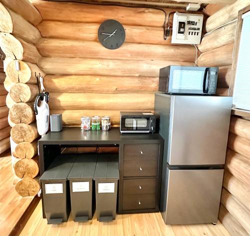a small kitchen with a refrigerator and a counter at Lodge Kurokawa 1 in Minamioguni