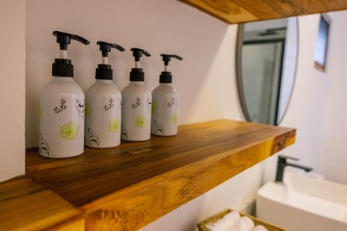 a row of four bottles on a shelf in a bathroom at Castle Residence by Aura Space in Paje