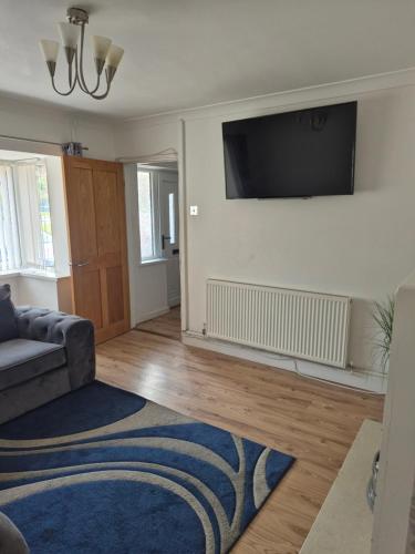 a living room with a couch and a flat screen tv at Quiet and professional friendly in Cardiff