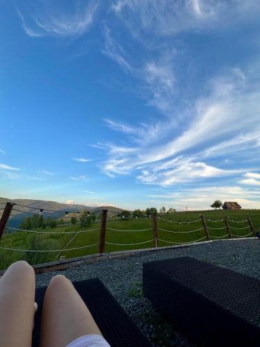 a person laying on a bench looking out at a field at Old Man's Cabin in Măguri