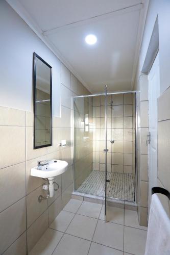 a bathroom with a shower and a sink at Ferry Palms Guest Lodge in Arcadia