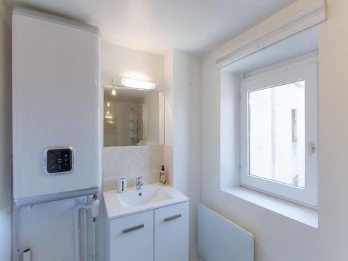 baño blanco con lavabo y ventana en Résidence Greenwich, en Metz