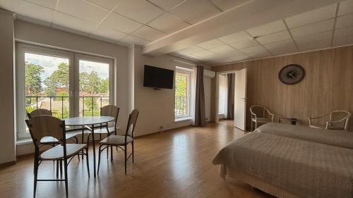a bedroom with a bed and a table and chairs at Parko Studija in Birštonas