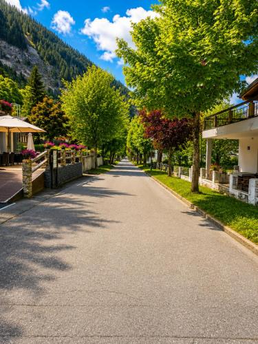 an empty street with trees and a building at Schlossli-Le Petit Chateau in Leukerbad