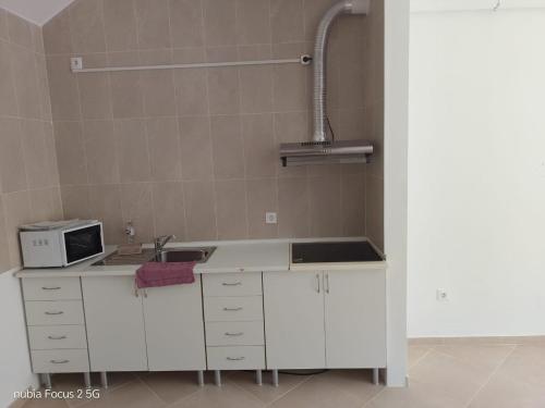 a kitchen with a sink and a microwave at Fort Apartments in Vila do Porto