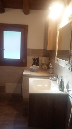 a bathroom with a white sink and a window at KaraA'mare in San Teodoro