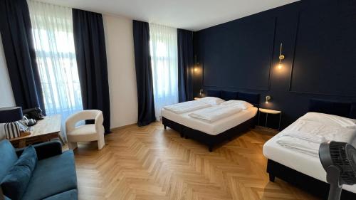 ein Hotelzimmer mit zwei Betten und einer Couch in der Unterkunft Kolbeck Rooms in Wien