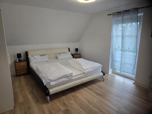 a bedroom with a bed with white sheets and a window at S&P Dream Apartment in Backnang