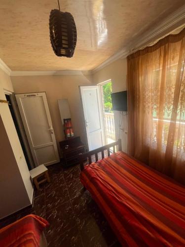 a bedroom with a red bed and a window at KARTSIVADZe in Ureki