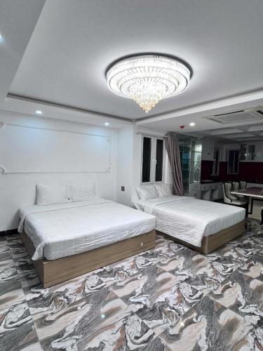 a bedroom with two beds and a chandelier at Michael Hotel in Nha Trang