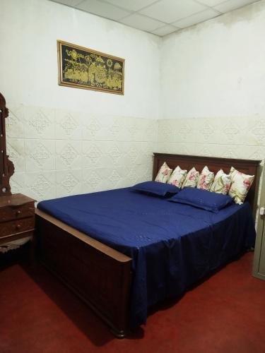 a bedroom with a bed with blue sheets and pillows at Mount crest homestay in Kandy
