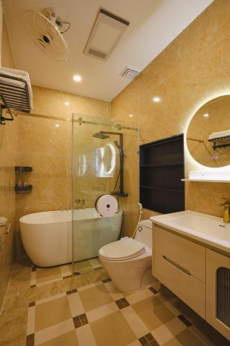 a bathroom with a tub and a toilet and a sink at Celestia Hue Villa in Hue