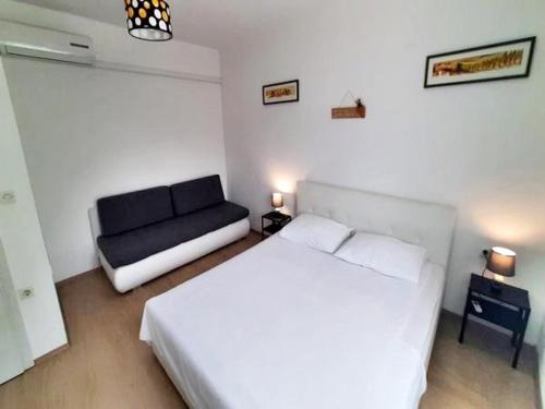 a bedroom with a white bed and a couch at Villa Marina in Poljica