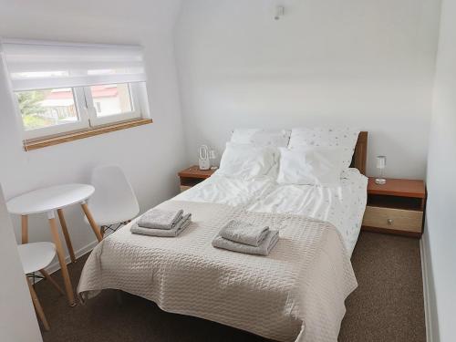 a bedroom with a bed with two towels on it at Łapacz Mazurskich Chwil in Orzysz