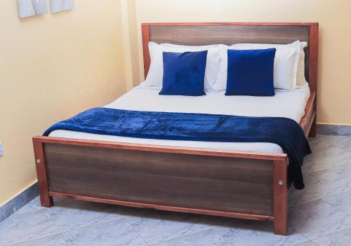 a bed with blue and white pillows on it at Countryside Apartment 1 in Kiambu
