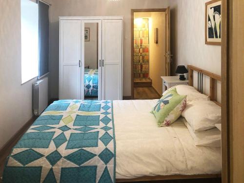 a bedroom with a bed with a quilt on it at Gite Julie Anne in Ussat