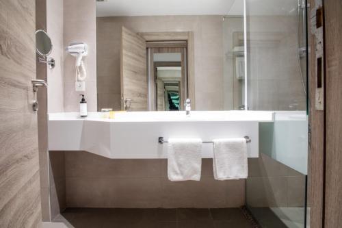a bathroom with a white sink and a mirror at Golden Tulip Amman in Amman