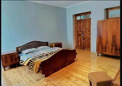 a bedroom with a bed and a wooden floor at Madisha's Guesthouse in Mestia