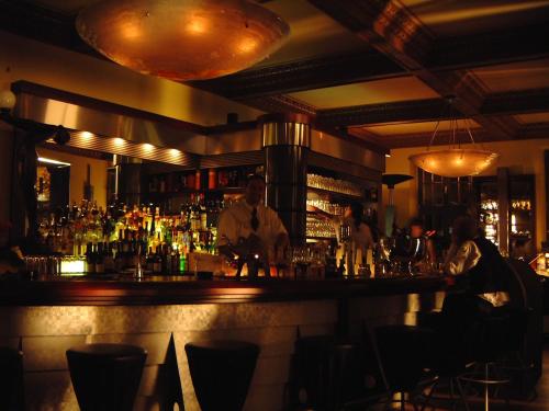 a bar with a man standing behind the bar at City-Hotel in Plauen