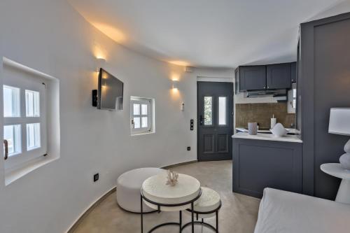 a living room with a table and a kitchen at Topos Exclusive Santorini in Imerovigli