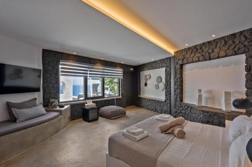 a bedroom with a large bed and a couch at Topos Exclusive Santorini in Imerovigli