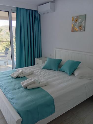 a bedroom with a large bed with blue pillows at Poseidon Complex in Paleokastritsa