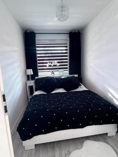 a bedroom with a bed with a black comforter at Apartament Borys in Malbork