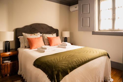 a bedroom with a large bed with orange pillows at Provesende Douro Villas - Casa Principal in Provesende
