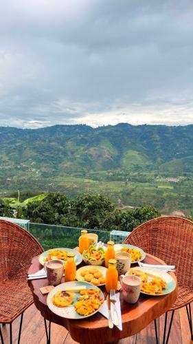 a table with plates of food and orange juice at Montecielo in Pitalito