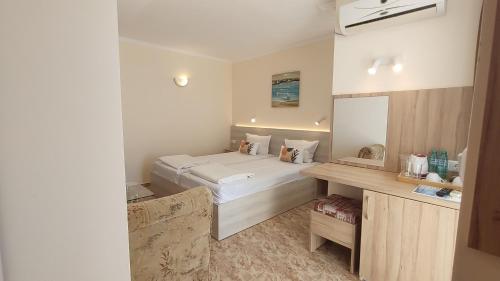 a bedroom with a bed and a desk in it at CASA DEL SOL Sozopol in Sozopol