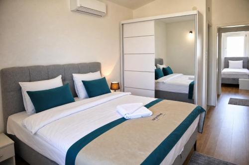 a bedroom with a large bed with a mirror at Sarajevo Resort Gestoria in Hadžići