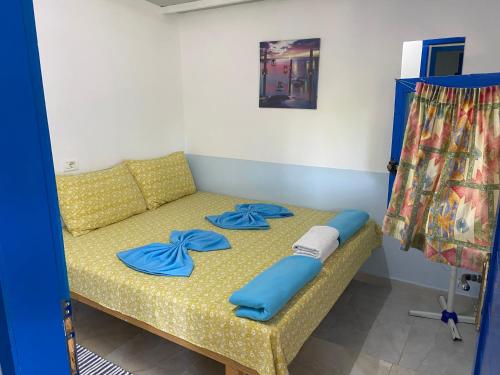 a bed in a room with blue pillows on it at Glamping Rooms at The Sea Turtle in Dhërmi