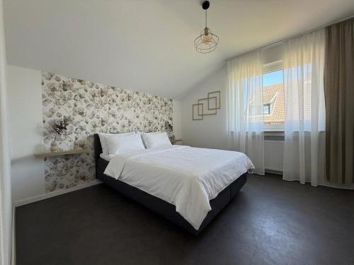 a bedroom with a large bed and a window at Karolinger Stay in Emmerich