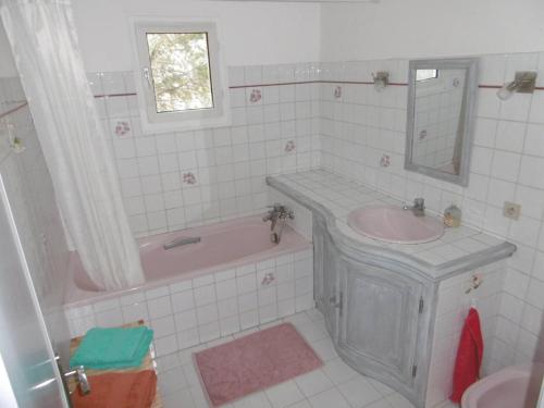 a bathroom with a sink and a tub and a mirror at Chambre dans maison provençale avec piscine in Cavaillon