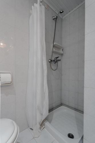 a shower with a white shower curtain in a bathroom at Domus Alta in Tsilivi
