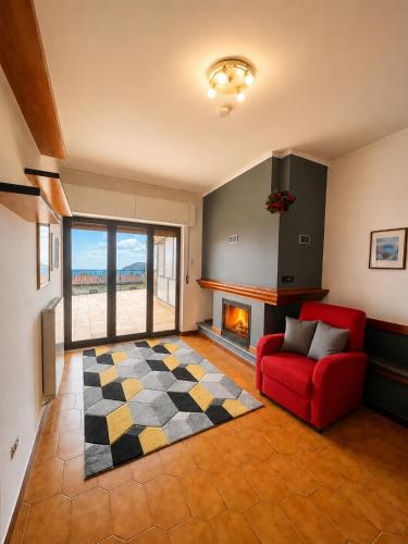 a living room with a red couch and a fireplace at Sa Omu 'e Pinucciu in Lanusei
