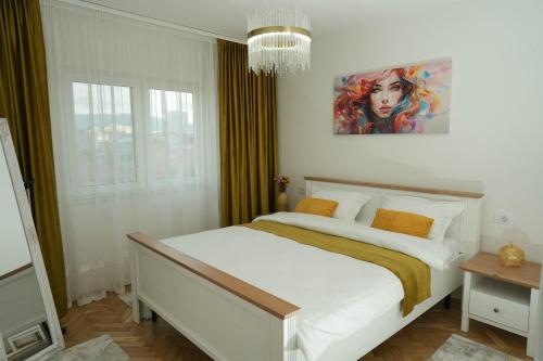 a bedroom with a bed with a painting on the wall at Ari's Arpartament in Beiuş