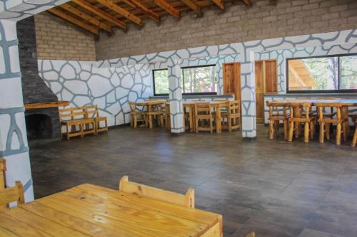 a dining room with wooden tables and chairs at Cabañas sierra grande in Creel