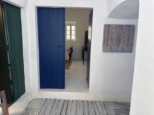 a blue door in a room with a hallway at Mylopotamos House in Milopótamos