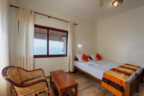 a bedroom with a bed and a table and a window at Cherai Onetree Retreat in Cherai Beach